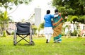 focus on armchair, Nurse taking walk by supporting senior old woman from wheelchair - concept rehabilitation, caretaker