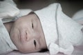 Focus at Asian baby girl with gray hat while sleeping and playing on the bed / Close up at cute newborn is looking at camera