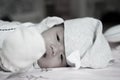 Focus at Asian baby girl with gray hat while sleeping and playing on the bed / Close up at cute newborn is looking at camera