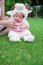 Focus at Asian newborn baby girl with costumes little sheep in the garden and mother is holding her. Royalty Free Stock Photo