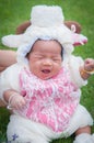 Focus at Asian newborn baby girl with costumes little sheep in the garden and mother is holding her.