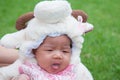 Focus at Asian newborn baby girl with costumes little sheep in the garden and mother is holding her. Royalty Free Stock Photo