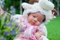 Focus at Asian newborn baby girl with costumes little sheep in the garden and mother is holding her. Royalty Free Stock Photo