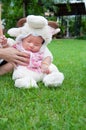 Focus at Asian newborn baby girl with costumes little sheep in the garden and mother is holding her. Royalty Free Stock Photo