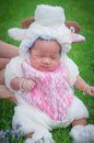 Focus at Asian newborn baby girl with costumes little sheep in the garden and mother is holding her. Royalty Free Stock Photo