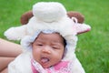 Focus at Asian newborn baby girl with costumes little sheep in the garden and mother is holding her. Royalty Free Stock Photo