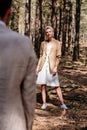Focus of attractive sylish bride looking at bridegroom in forest