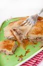 Focus on a burek on the fork with burek in the background Royalty Free Stock Photo