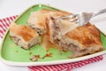 Focus on a burek on the fork with burek in the background Royalty Free Stock Photo