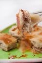 Focus on a burek on the fork with burek in the background Royalty Free Stock Photo