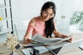 Focus of cheerful asian woman in glasses reading newspaper in office Royalty Free Stock Photo