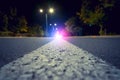 Focus on city road with blurred police car red and blue lights in the distance, crime and accident concept