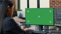 Focus on computer screen with green screen chroma key mockup in front of asian programer writing code