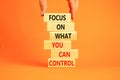 Focus on control symbol. Concept words Focus on what you can control on wooden block. Beautiful orange table orange background. Royalty Free Stock Photo