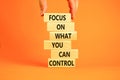 Focus on control symbol. Concept words Focus on what you can control on wooden block. Beautiful orange table orange background. Royalty Free Stock Photo
