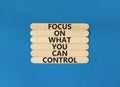 Focus on control symbol. Concept words Focus on what you can control on wooden stick. Beautiful blue table blue background. Royalty Free Stock Photo