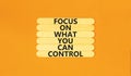 Focus on control symbol. Concept words Focus on what you can control on wooden stick. Beautiful orange table orange background. Royalty Free Stock Photo