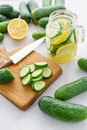 Focus on cucumber slices. Summer cocktail cucumber lemonade. Refreshing water with cucumber, mint and lemon on grey Royalty Free Stock Photo