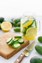 Focus on cucumber slices. Summer cocktail cucumber lemonade. Refreshing water with cucumber, mint and lemon on grey Royalty Free Stock Photo