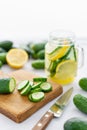 Focus on cucumber slices. Summer cocktail cucumber lemonade. Refreshing water with cucumber, mint and lemon on grey Royalty Free Stock Photo