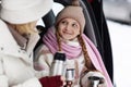 Focus on cute smiling girl in winterwear looking at her mother