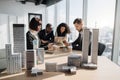 Focus on 3d city model. Business team of four good-looking multiethnic corporate workers