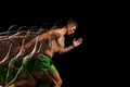 Focus and determination. Shirtless, muscular man in motion, training, running against black background with stroboscope
