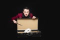 Focus disappearance white rabbit in suitcase, magician conjures magic wand, black background