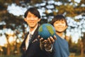 Focus Earth with blurred asian boy and businessman holding globe together. Gyre