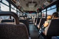 Focus on an empty seat in a bus with only a single mother and child in the distance. Royalty Free Stock Photo