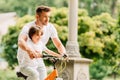 Focus of father and son looking forward while kid riding bicycle and dad helping boy Royalty Free Stock Photo