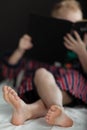 Focus on feet of little boy reading