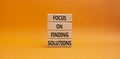 Focus on finding solutions symbol. Concept words Focus on finding solutions on wooden blocks. Beautiful orange background. Royalty Free Stock Photo