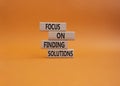 Focus on finding solutions symbol. Concept words Focus on finding solutions on wooden blocks. Beautiful orange background. Royalty Free Stock Photo