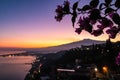 Focus on flower with view on snow capped Mount Etna volcano during at from public garden Parco Duca di Cesaro in Taormina Sicily Royalty Free Stock Photo