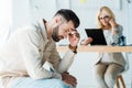 Focus of frustrated man sitting near blonde recruiter