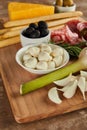 Focus of garlic, rosemary, salami slices, bowls with olives and mozzarella, breadsticks and cheese Royalty Free Stock Photo