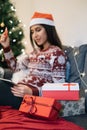 In focus gift boxes and blurred woman holding tablet and card