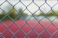 Blurry tennis court with focus on a fence