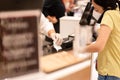 Focus on hand of cashier taking receipt paper bill from card reader. Royalty Free Stock Photo