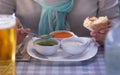 Focus on the hands of a Caucasian woman enjoying the food at the restaurant table tasting the three typical sauces of the Canary