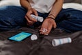 Focus on hands of depressed teenage girl scattering pills on palm