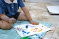 Focus on hands on paper, early childhood learning by using paints and brushes to build imagination and enhance skills on Royalty Free Stock Photo