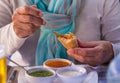 Focus on the hands of a woman enjoying the three.typical sauces of the Canary Islands, called