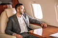 Focus of handsome businessman listening music and looking at airplane window Royalty Free Stock Photo