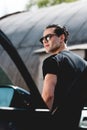 Focus of handsome stylish man in sunglasses posing near car Royalty Free Stock Photo