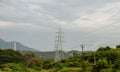 Focus on high voltage power transmission poles distributing power from hydro electric plant Royalty Free Stock Photo