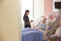 Focus On Hospital Room Sign With Doctor Talking To Patient Royalty Free Stock Photo