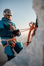 Focus on ice axe. Man climber with equipment and ropes on the slope at background Royalty Free Stock Photo