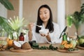 Focus on ingredients for homemade cosmetics lying on wooden table, blurred happy asian woman